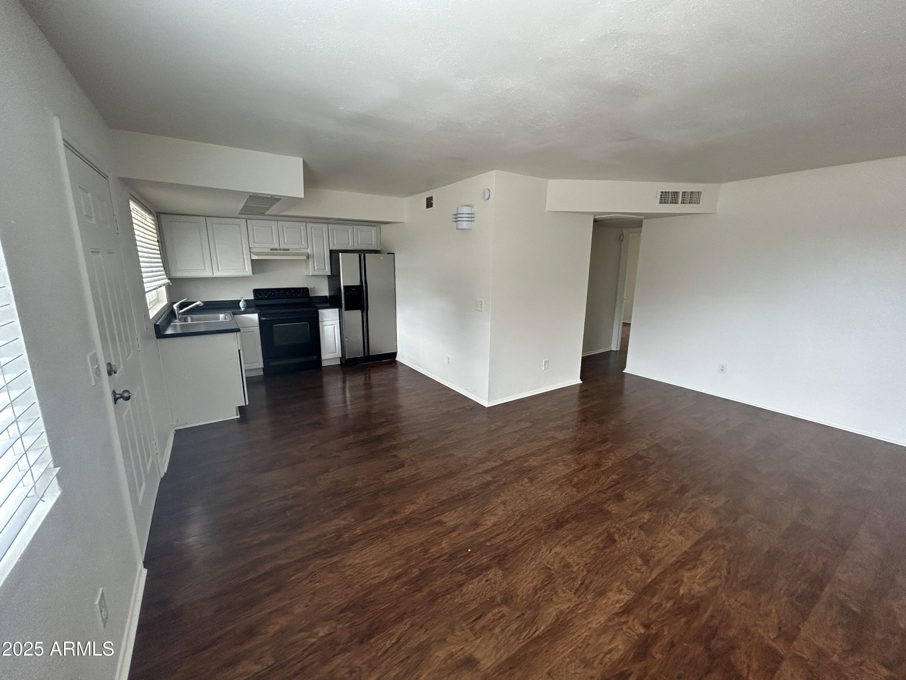 45 North Phyllis, Unit 109 Mesa, AZ 85201 - Photo 7 of 28 a view of a kitchen with a sink refrigerator and wooden floor