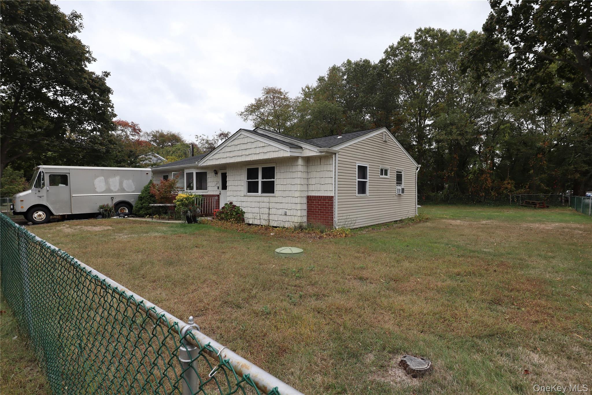 143 Jefferson Avenue Wyandanch, NY 11704 - Photo 32 of 37 a view of a house with a backyard and a tree
