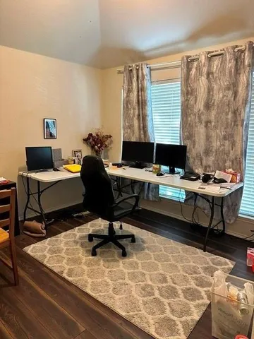 a view of a workspace with furniture and a window