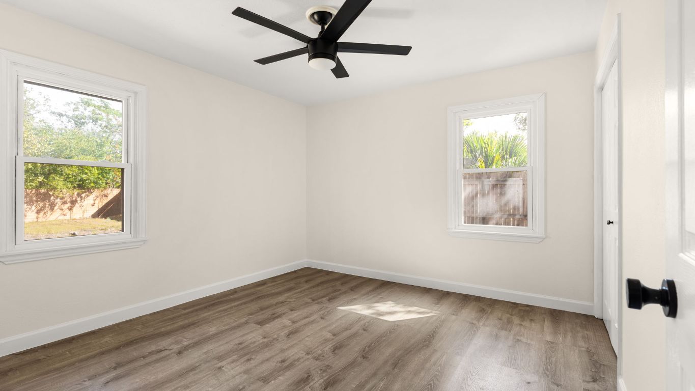 2118 Fordham Lane Austin, TX 78723 - Photo 19 of 28 a view of an empty room with wooden floor and a window