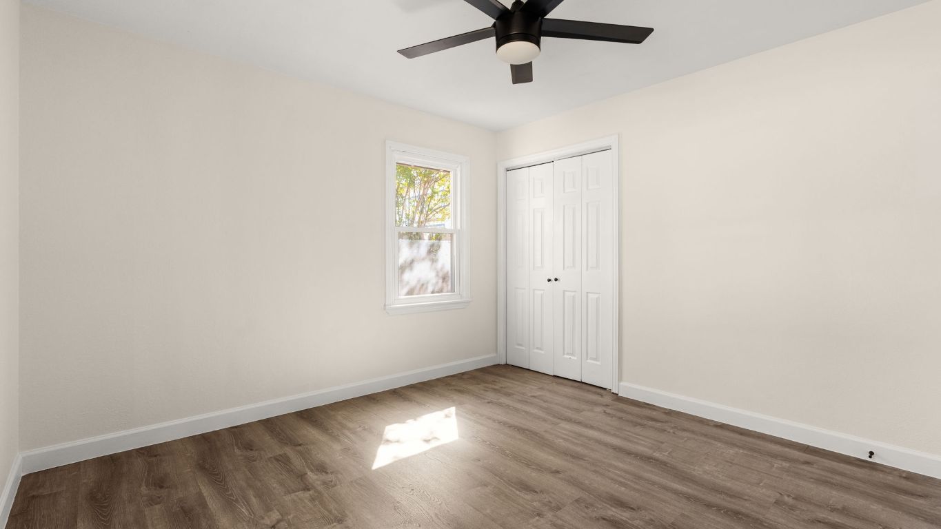 2118 Fordham Lane Austin, TX 78723 - Photo 20 of 28 an empty room with wooden floor ceiling fan and windows