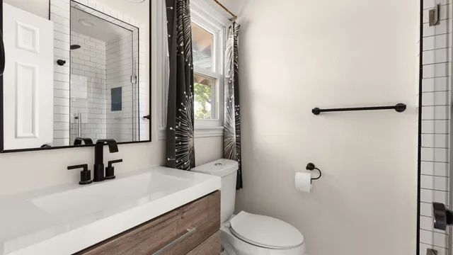 a bathroom with a sink a toilet and shower