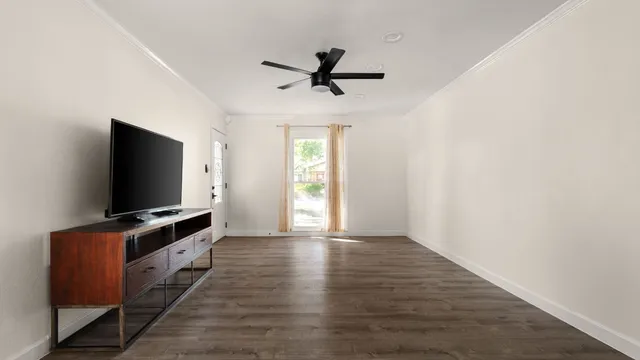 a living room with flat screen tv and windows