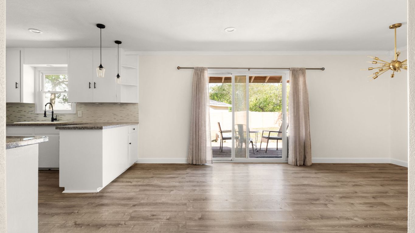 2118 Fordham Lane Austin, TX 78723 - Photo 8 of 28 a kitchen with granite countertop a stove a sink and white cabinets with wooden floor