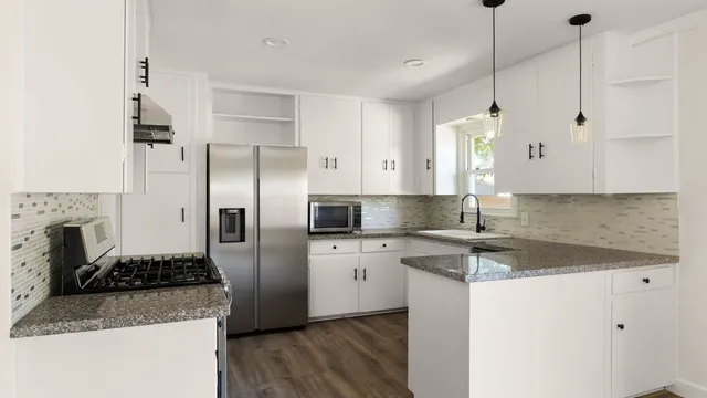 a kitchen with stainless steel appliances granite countertop a sink stove and refrigerator