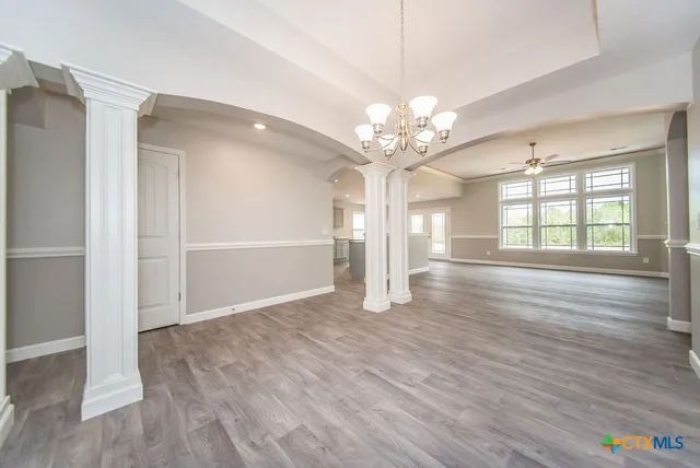 an empty room with windows fireplace and wooden floor