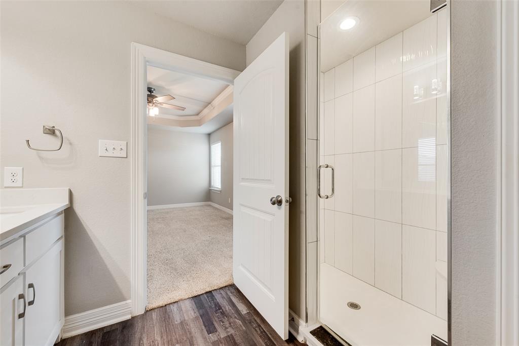 625 Copenhavr Street Pilot Point, TX 76258 - Photo 15 of 20 Bathroom with vanity, dark wood finished floors, a stall shower, and a ceiling fan
