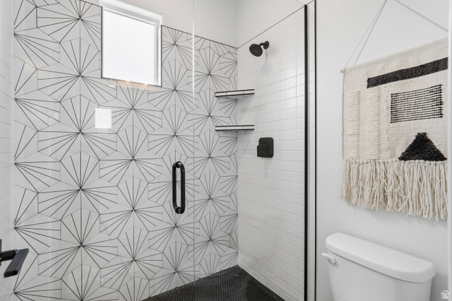 2278 Tawny Ridge Circle St. George, UT 84790 - Photo 43 of 61 Walk-in shower with geometric patterned tile accent wall, black hexagonal floor tile, and matte black fixtures.