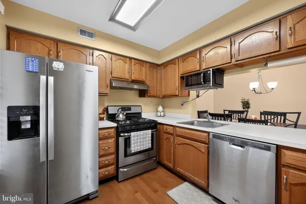 a kitchen with stainless steel appliances granite countertop a refrigerator a stove and a sink