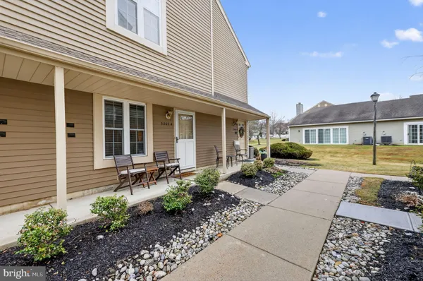 a front view of a house with garden and chairs