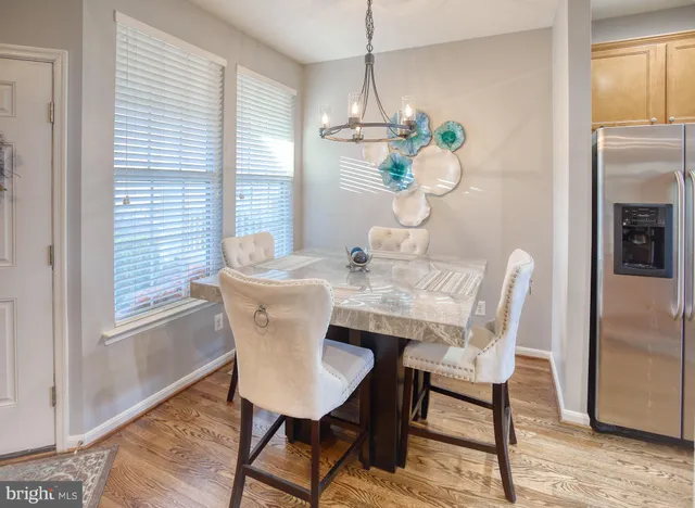 a kitchen with stainless steel appliances granite countertop a stove top oven a sink dishwasher and a refrigerator with wooden floor