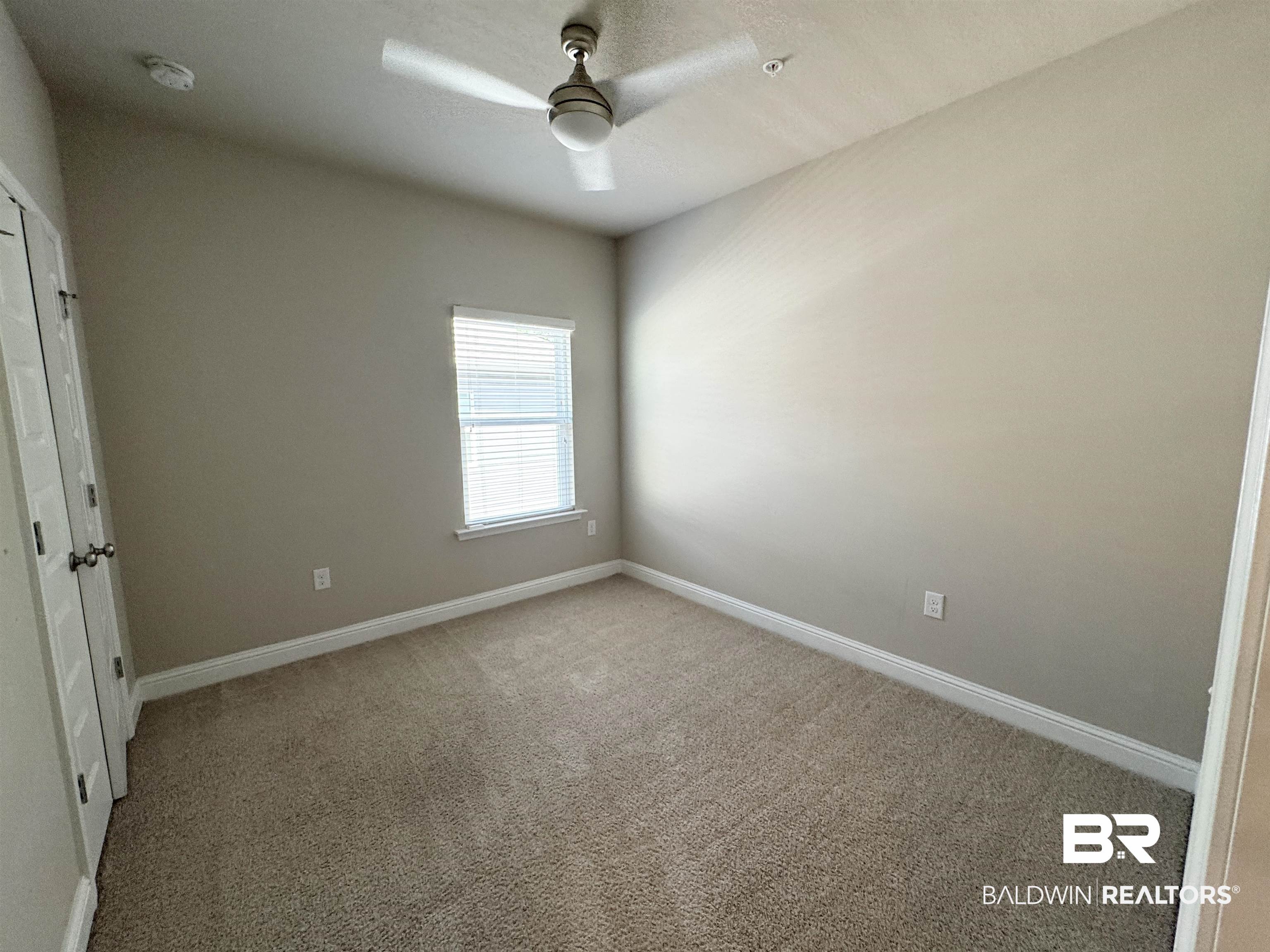 6811 Spaniel Drive, Unit C Daphne, AL 36527 - Photo 20 of 33 Spare room featuring light carpet, ceiling fan, baseboards, and a smoke detector