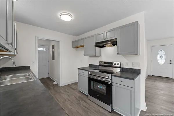 a kitchen with stainless steel appliances granite countertop a sink stove and cabinets
