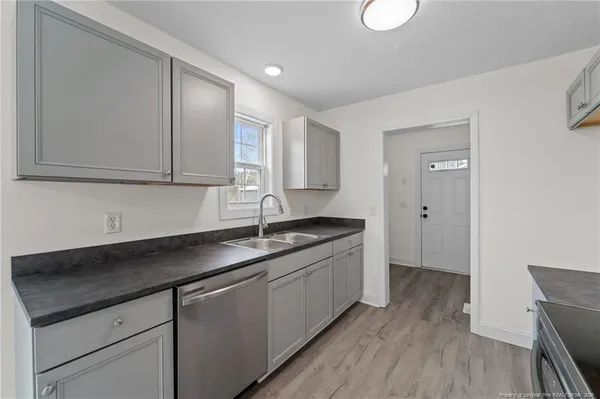 a kitchen with a sink cabinets and wooden floor
