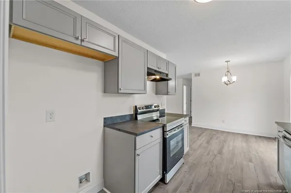 a kitchen with granite countertop cabinets stainless steel appliances a sink and a window