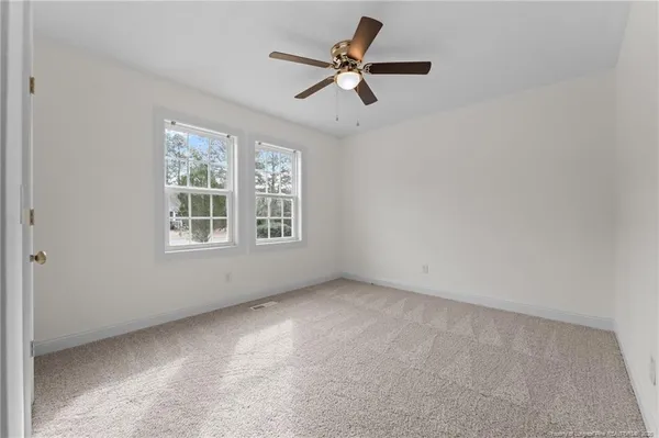 an empty room with chandelier fan