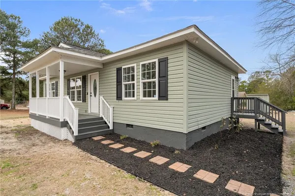 a view of a house with a patio and a yard