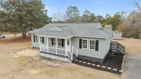 a front view of a house with a yard and wooden fence