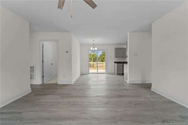 a view of empty room with wooden floor and a ceiling fan