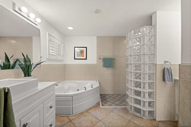 a bathroom with a tub sink and mirror