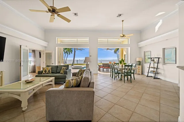 a living room with furniture kitchen view and a chandelier