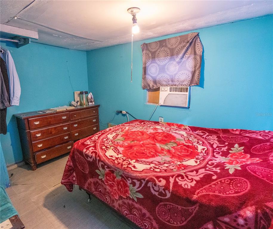 201 Maple Street Winter Haven, FL 33880 - Photo 11 of 16 a bedroom with a bed and a painting on the wall