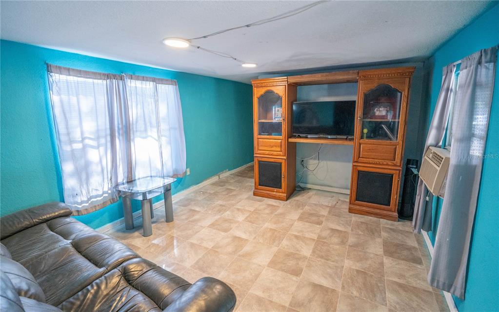 201 Maple Street Winter Haven, FL 33880 - Photo 15 of 16 a living room with furniture a window and a flat screen tv