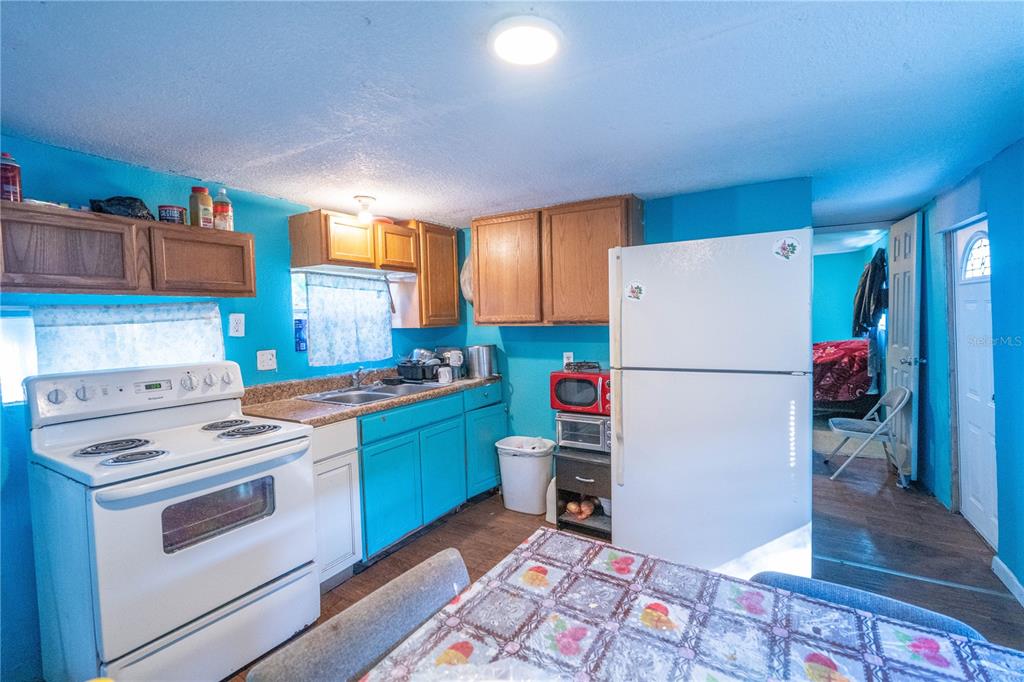 201 Maple Street Winter Haven, FL 33880 - Photo 8 of 16 a kitchen with a refrigerator and a stove top oven