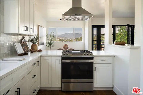 a kitchen with stainless steel appliances a stove a sink and a window