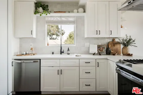 a kitchen with granite countertop white cabinets and white appliances