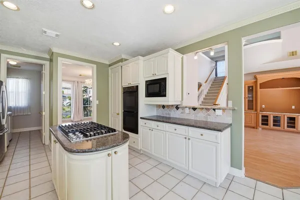 a kitchen with granite countertop a sink stove and refrigerator