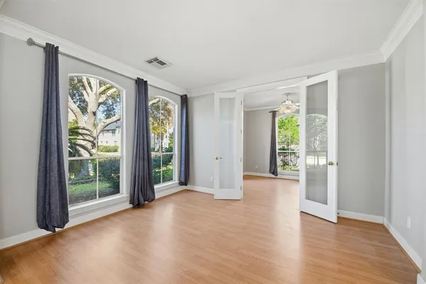 a view of an empty room with glass door and balcony