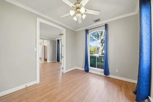 a view of an empty room with window and wooden floor