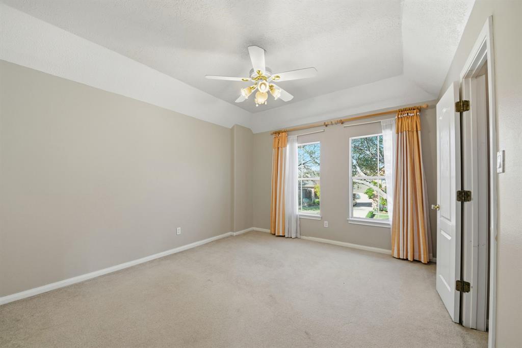5315 Ridgewood Reef Houston, TX 77041 - Photo 18 of 35 an empty room with chandelier fan and windows