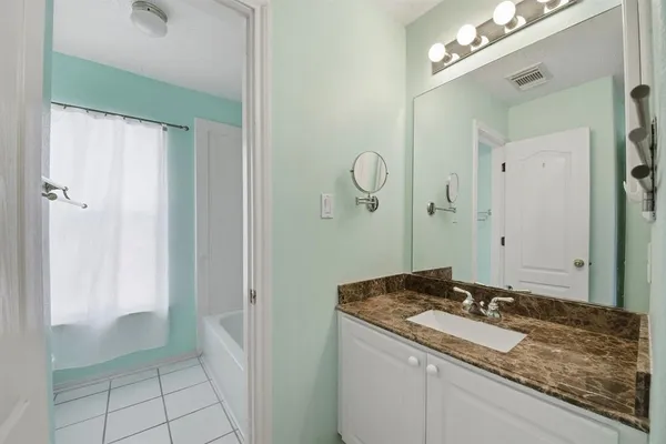 a bathroom with a granite countertop sink and a mirror