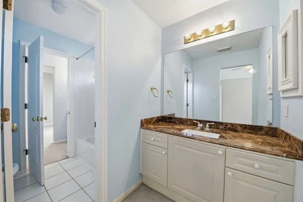 a bathroom with a granite countertop sink and a mirror