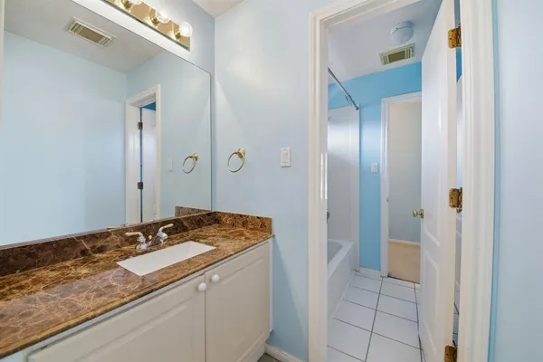 a bathroom with a granite countertop sink and a mirror