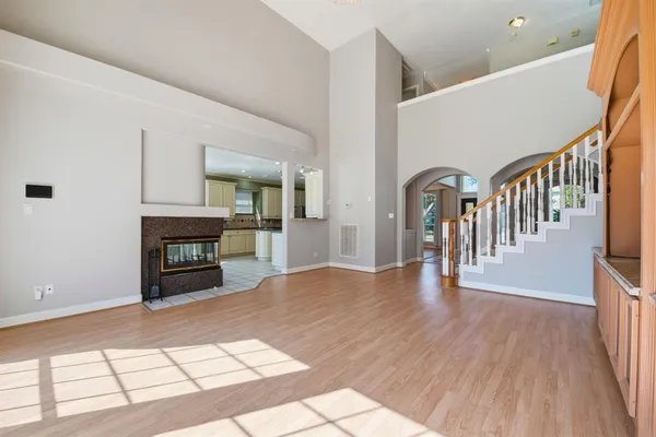 a view of a hallway with wooden floor and dining room