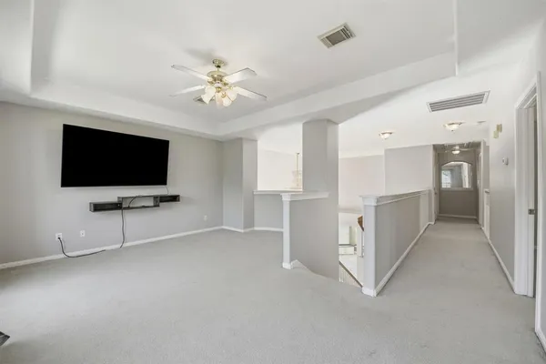 a living room with white walls and flat screen tv