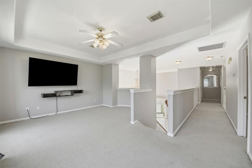 5315 Ridgewood Reef Houston, TX 77041 - Photo 10 of 35 a living room with white walls and flat screen tv
