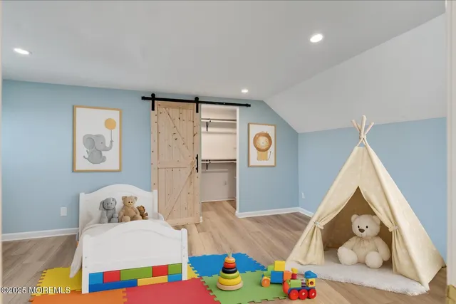 a bedroom with baby bed and a window