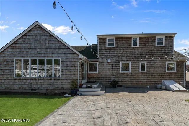 a backyard of a house with barbeque and wooden floor