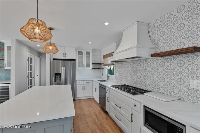 a kitchen with stainless steel appliances granite countertop a sink a stove a refrigerator and cabinets