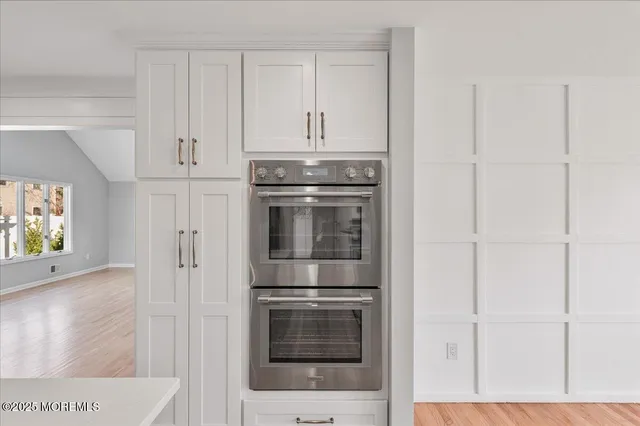 a kitchen with granite countertop white cabinets and stainless steel appliances