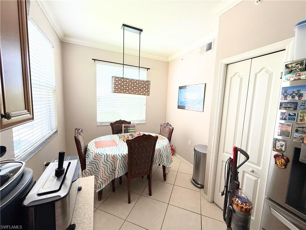 8490 Kingbird Loop, Unit 930 Estero, FL 33967 - Photo 3 of 12 Dining area with ornamental molding and light tile patterned flooring