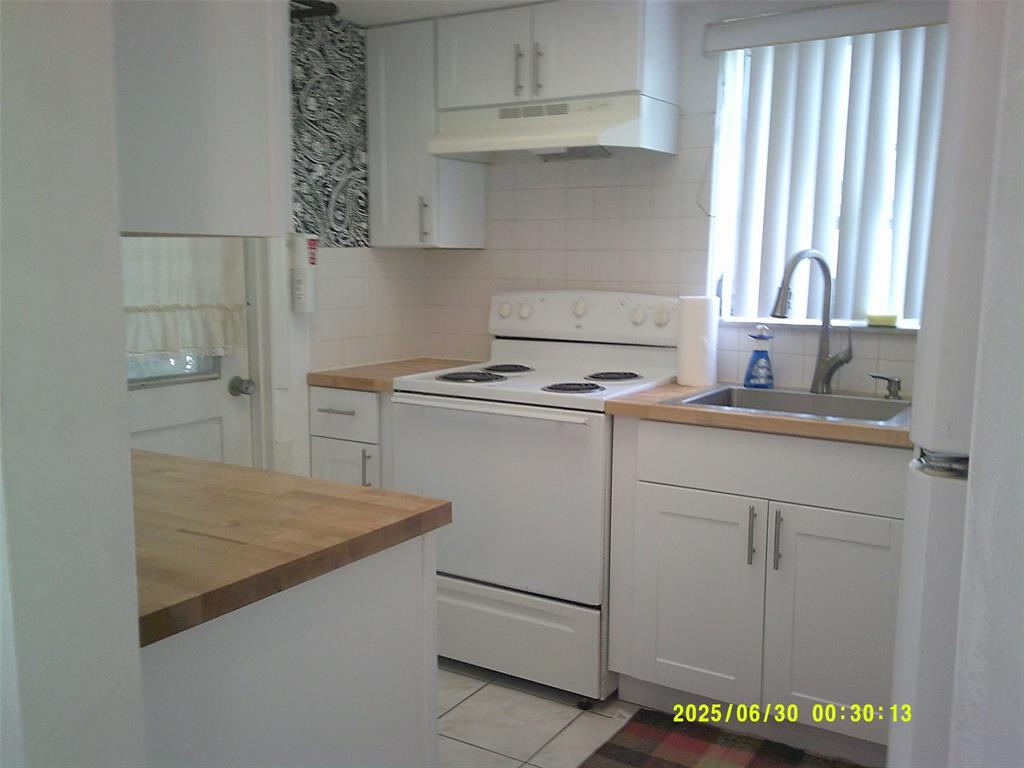 5800 Margate Boulevard, Unit 411 Pompano Beach, FL 33063 - Photo 14 of 30 a kitchen with cabinets appliances and a window