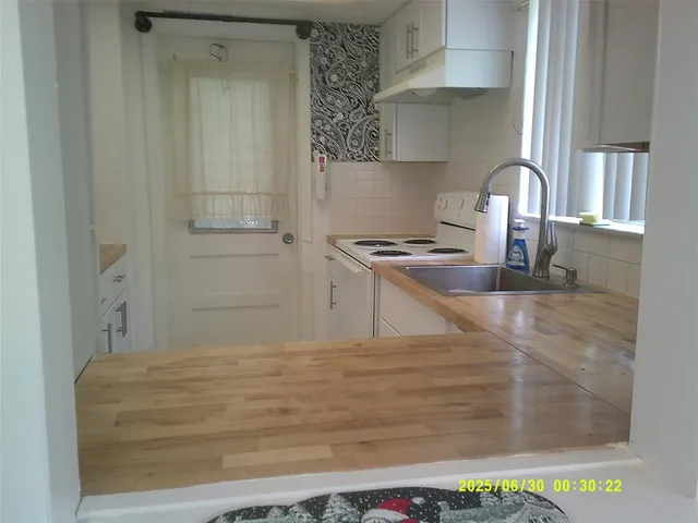 a kitchen with stainless steel appliances granite countertop a sink a stove and a wooden floors