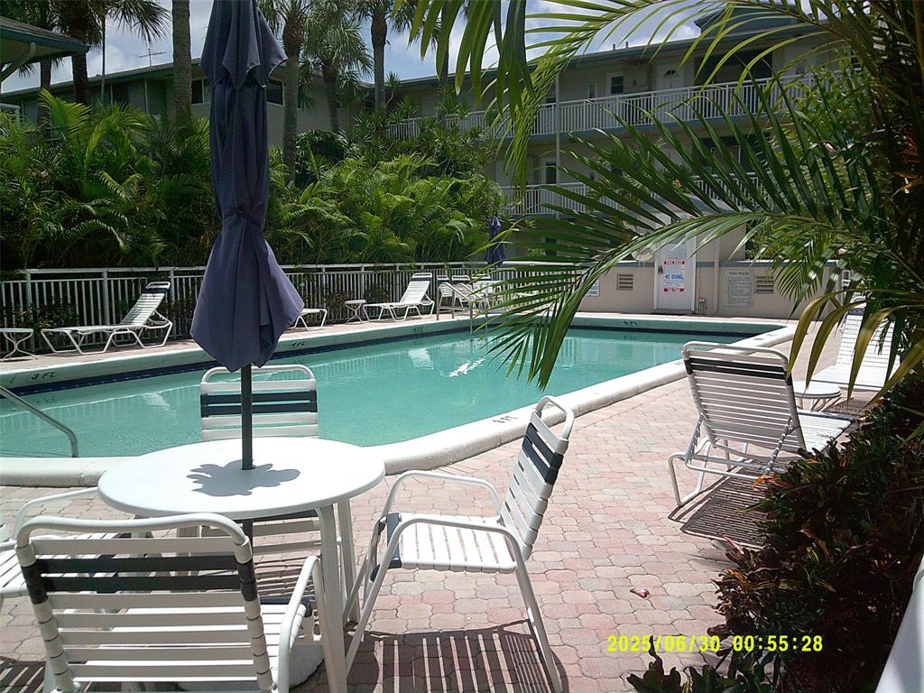 5800 Margate Boulevard, Unit 411 Pompano Beach, FL 33063 - Photo 27 of 30 a view of a swimming pool with a patio and a garden