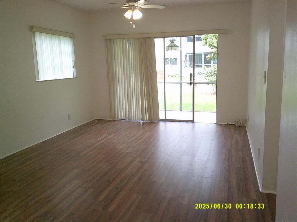 5800 Margate Boulevard, Unit 411 Pompano Beach, FL 33063 - Photo 6 of 30 a view of an empty room with wooden floor and a window