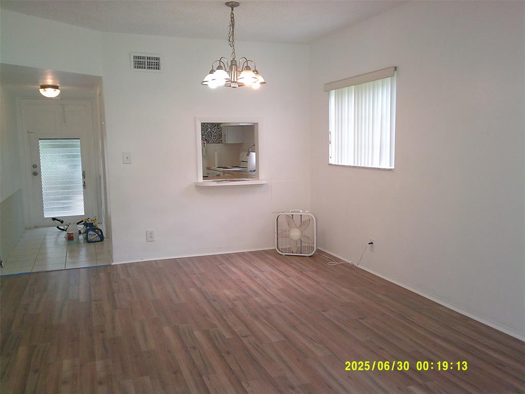 5800 Margate Boulevard, Unit 411 Pompano Beach, FL 33063 - Photo 8 of 30 a view of an empty room with wooden floor and a window